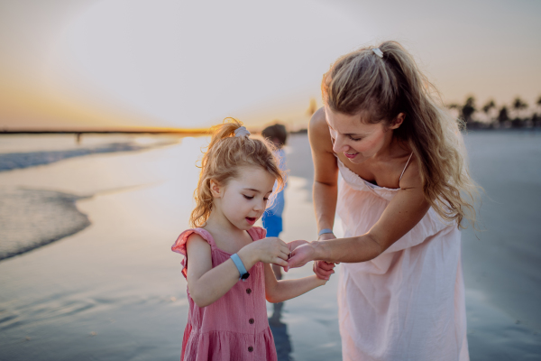 Mother with her little daughter enjoying time at the sea.