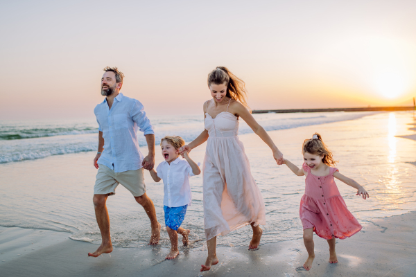 Happy family with little kids enjoying time at the sea in exotic country.