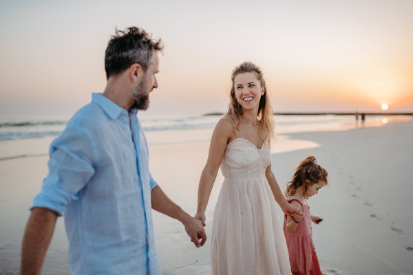 Happy family with little daughter enjoying time at the sea in exotic country.