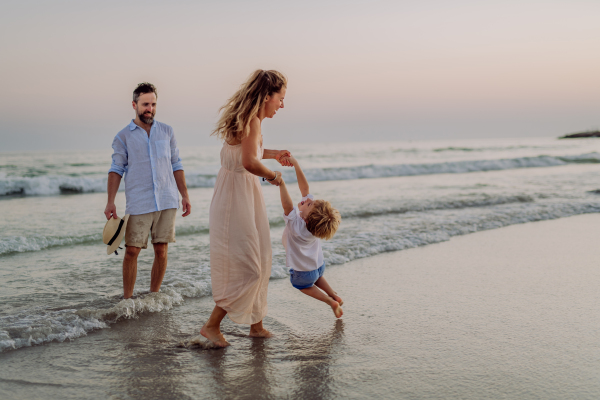 Happy family with little son enjoying time at the sea in exotic country.