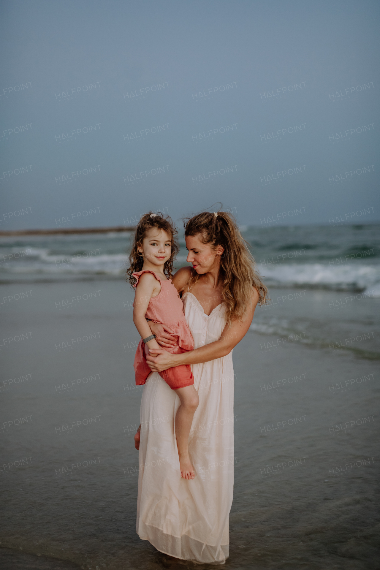 Mother enjoying together time with her daughter at the sea.