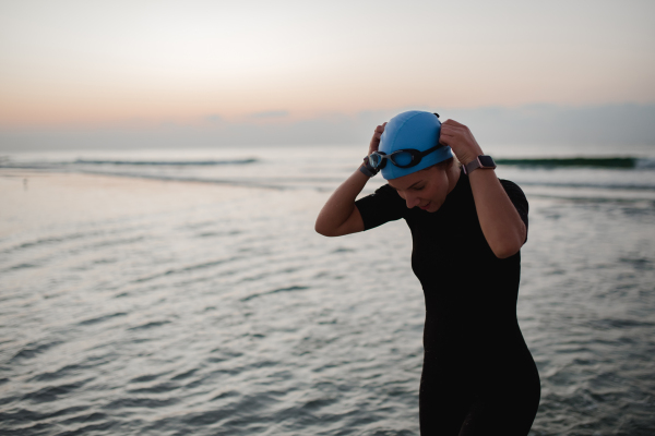 Young woman preparing for diving on the beach.