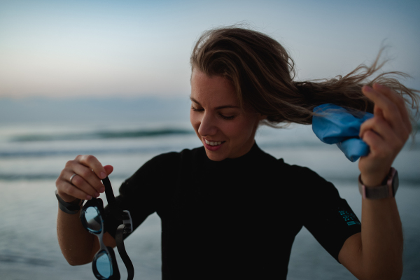 Young woman preparing for diving on the beach.