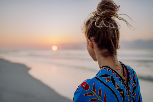 Rear view of young woman enjoying time at ocean.