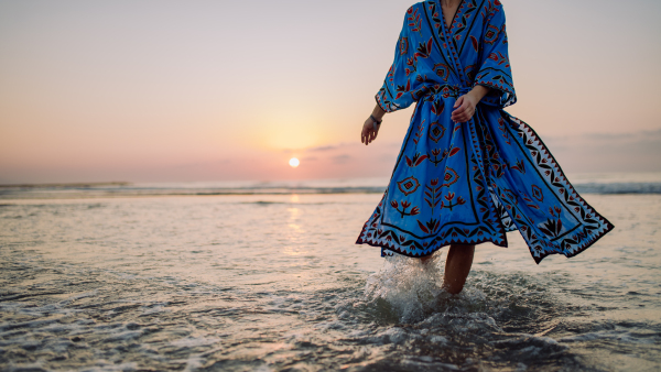 Low section of woman in orient dress enjoying ocean.