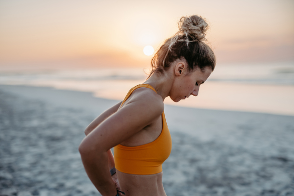 Close-up of young sportive woman at the beach.