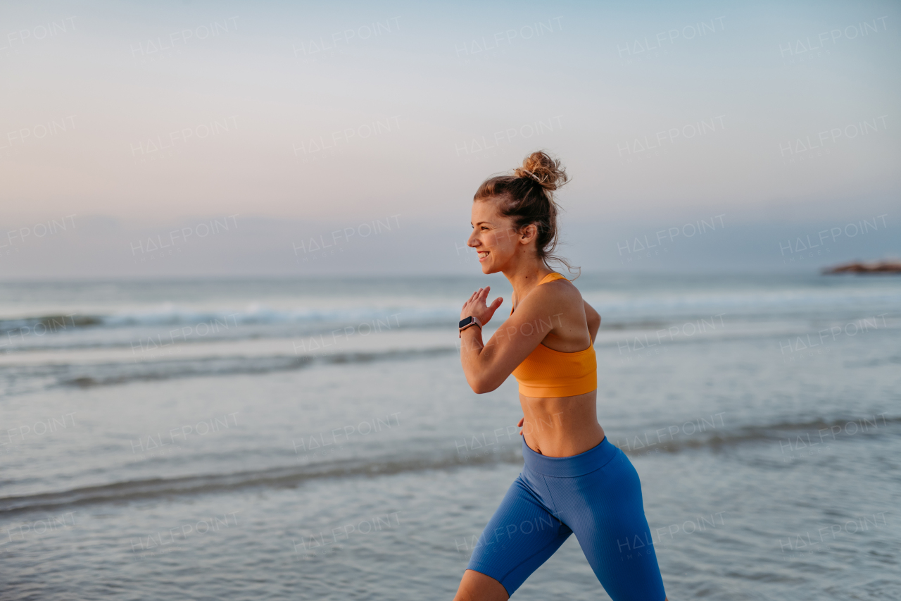 Young woman running at the beach, morning routine and healthy lifestyle concept.