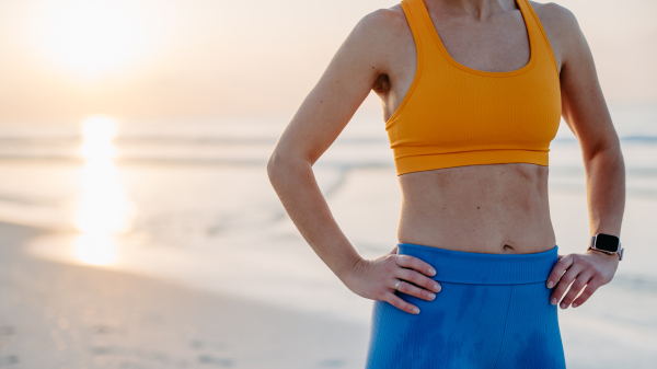 Close-up of young sportive woman at the beach.