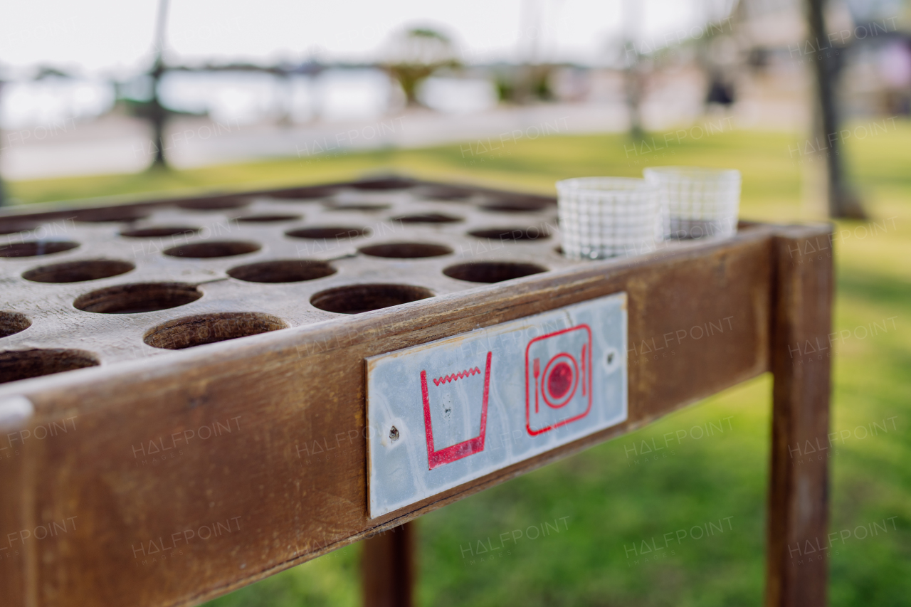 Close-up of storage table for empty glasses on a beach.