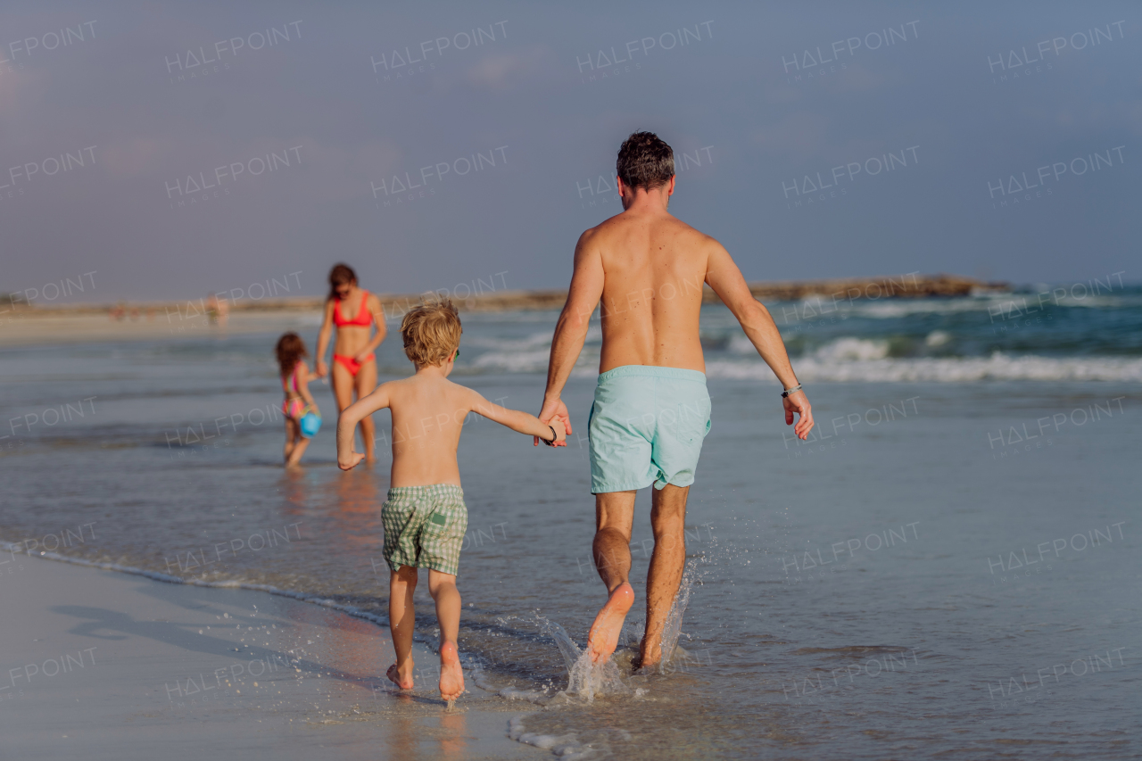 Happy family with little kids enjoying time at the sea in exotic country.