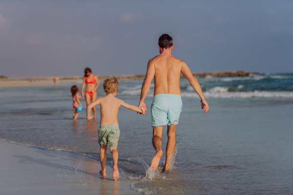 Happy family with little kids enjoying time at the sea in exotic country.