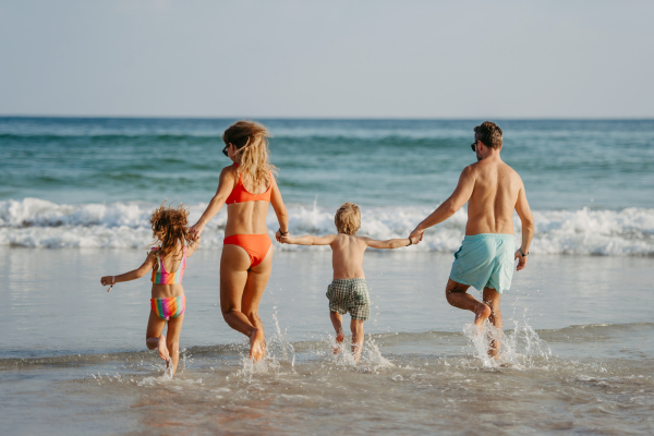 Happy family with little kids enjoying time at the sea in exotic country.