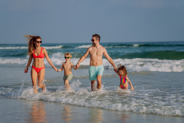 Happy family with little kids enjoying time at the sea in exotic country.