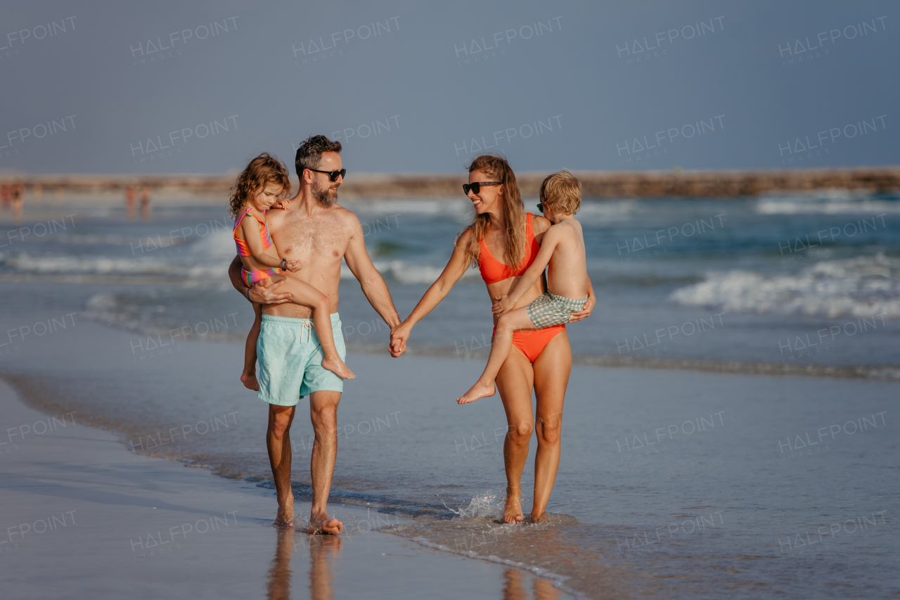 Happy family with little kids enjoying time at the sea in exotic country.