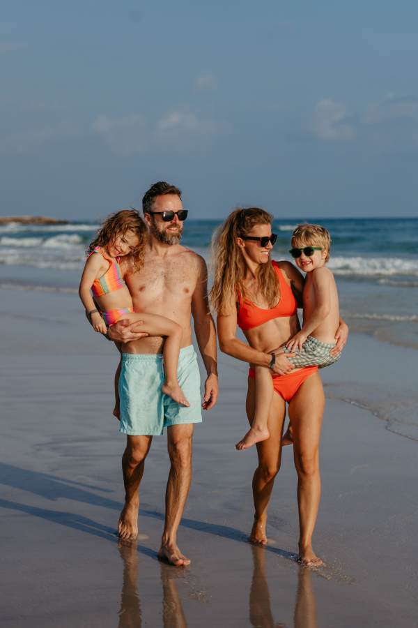 Happy family with little kids enjoying time at the sea in exotic country.