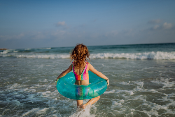 Rear view of little girl enjoying the sea.