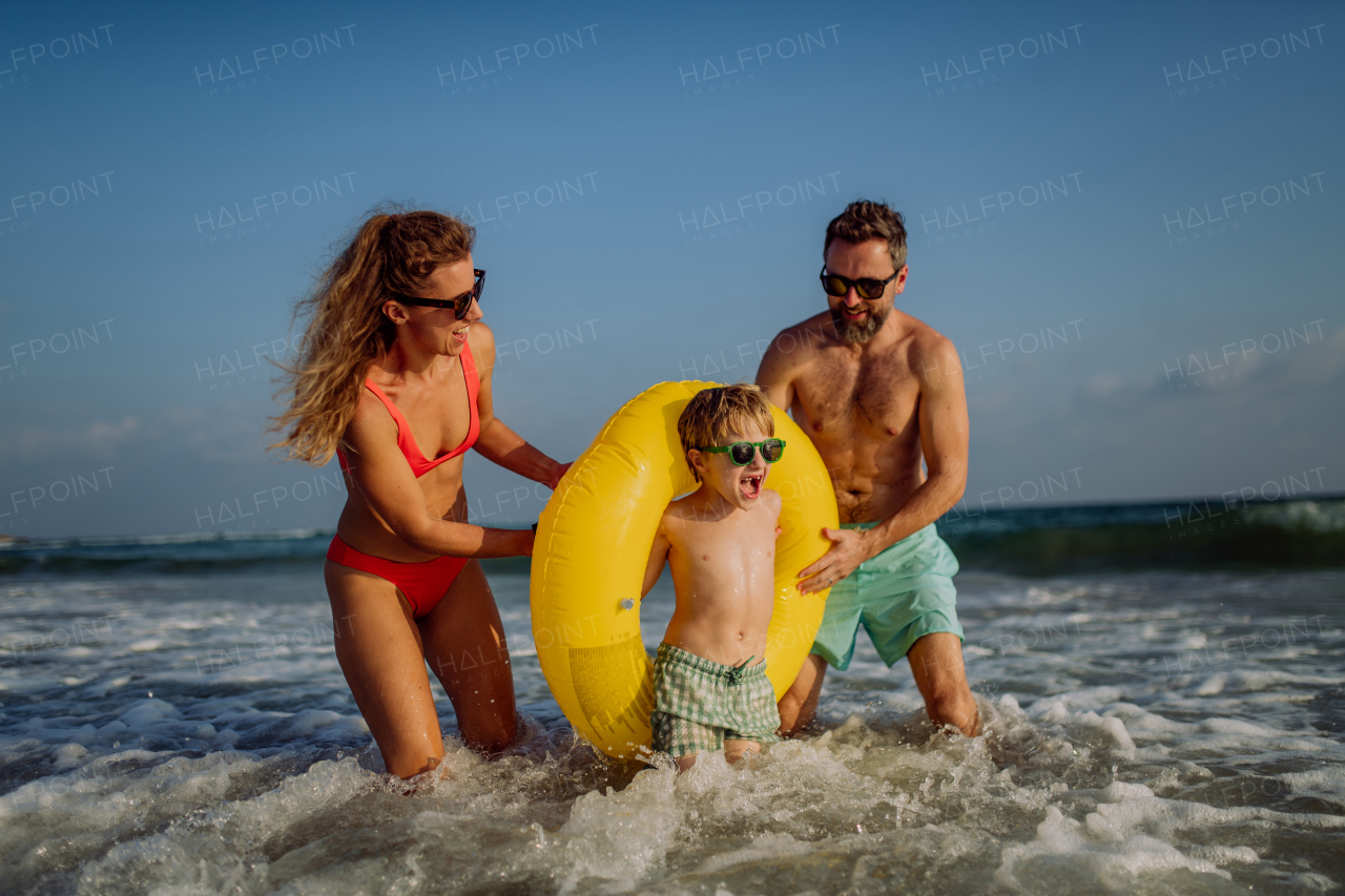 Happy family with little son enjoying time in the sea in exotic country.