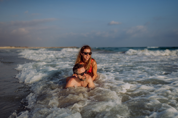 Happy couple in water, enjoying ocean together.