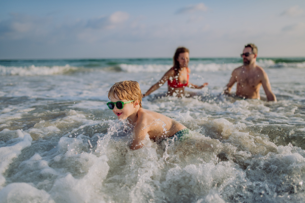 Happy family with little son enjoying time in the sea in exotic country.