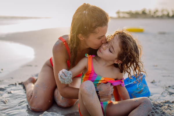 Mother with her little daughter enjoying time at the sea.