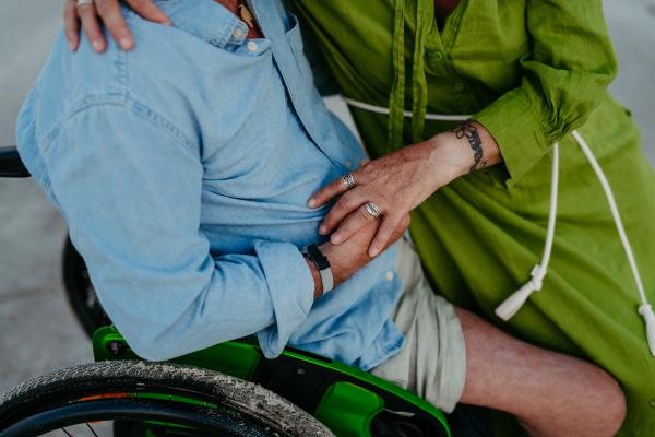 Close-up of senior man on wheelchair enjoying together time with his wife at the sea.