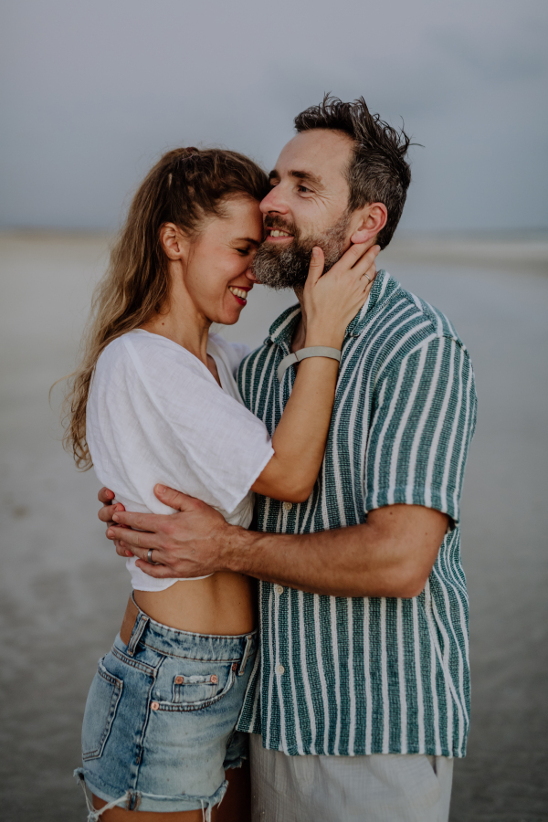 Portrait of happy couple, hugging and enjoying holiday at sea.