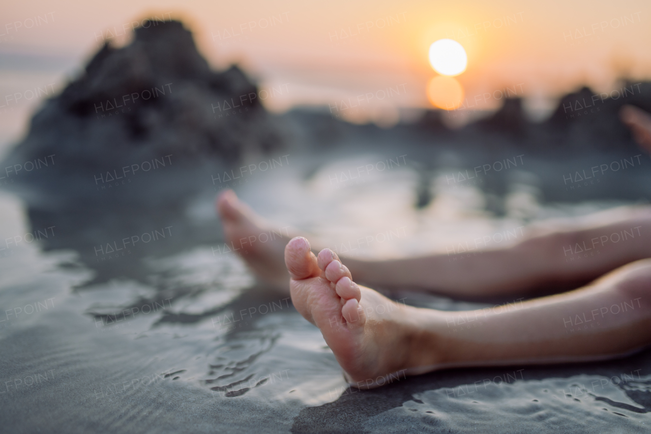 High angle view of childs legs in the ocean.