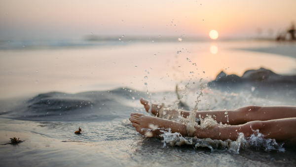 Side view of childs legs in the ocean.