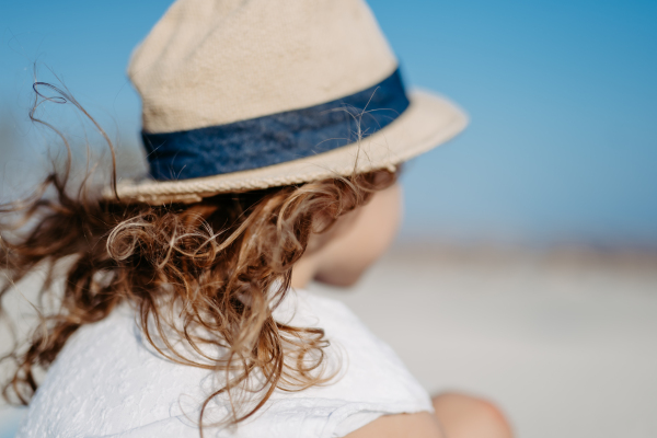 Side view of little girl looking at the ocean.