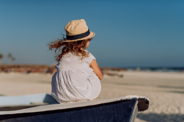 Rear view of little girl looking at the ocean.