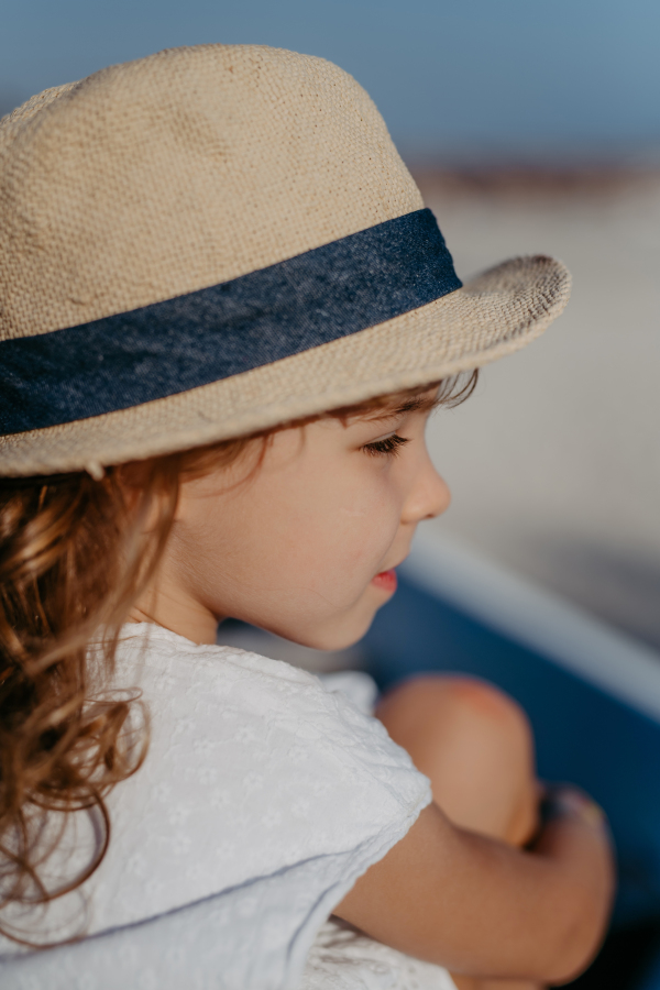 Side view of little girl looking at the ocean.