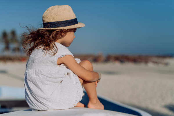 Rear view of little girl looking at the ocean.