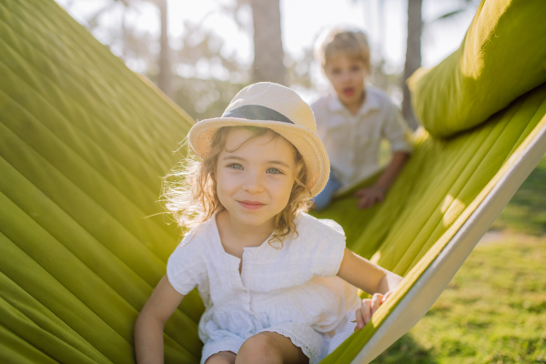 Little siblings enjoying their holiday in exotic country, lying in hammock.