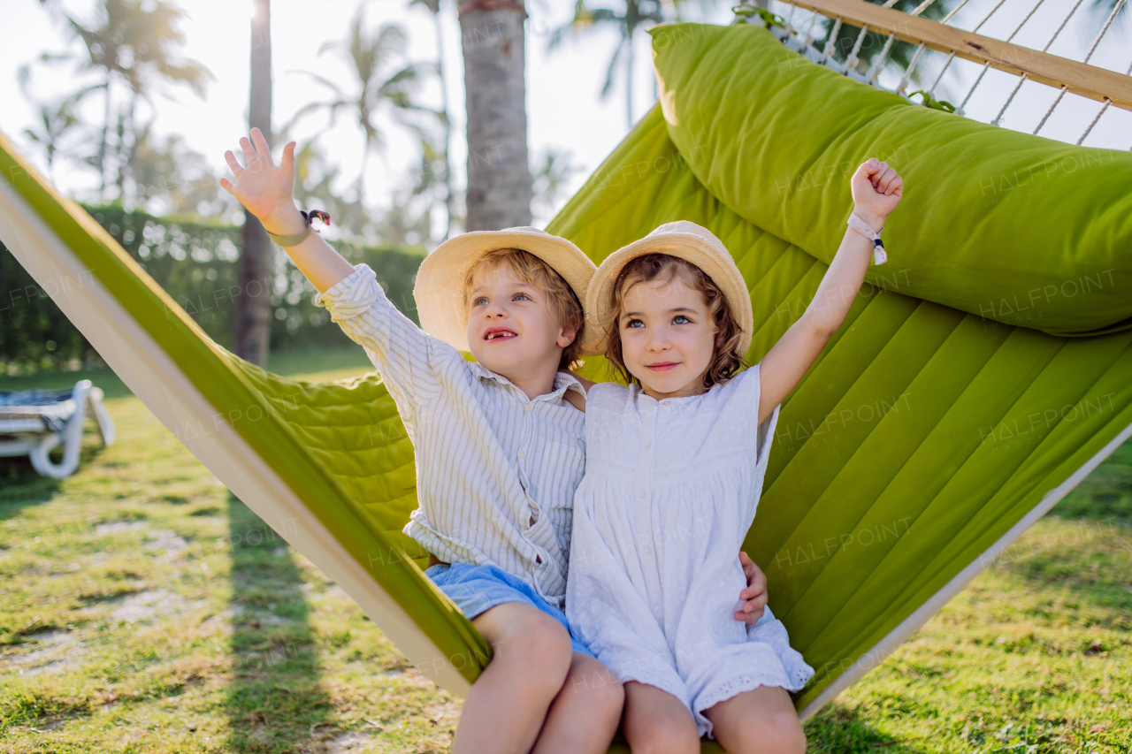 Little siblings enjoying their holiday in exotic country, lying in hammock.