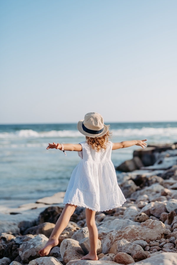 Rear view of little girl looking at the ocean.