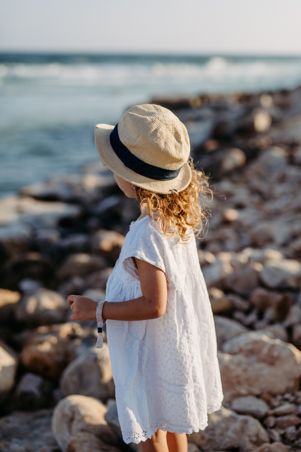 Rear view of little girl looking at the ocean.