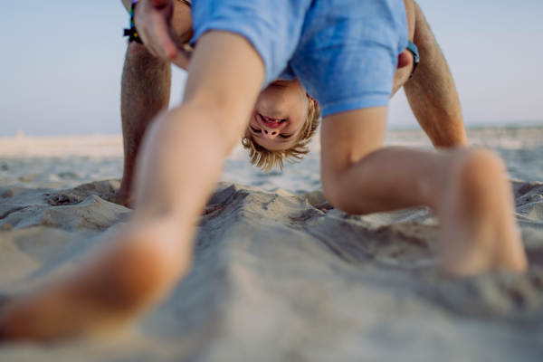 Father playing with his son, enjoying summer vacation and having fun.