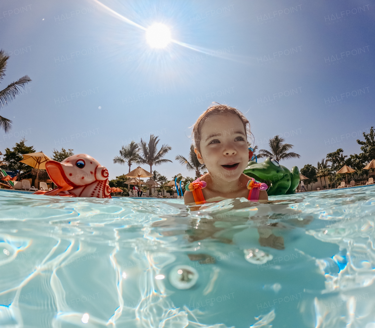 Little girl enjoying water amusement park during family holiday in exotic country.