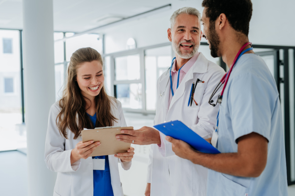 Team of doctors discussing something at a hospital corridor.