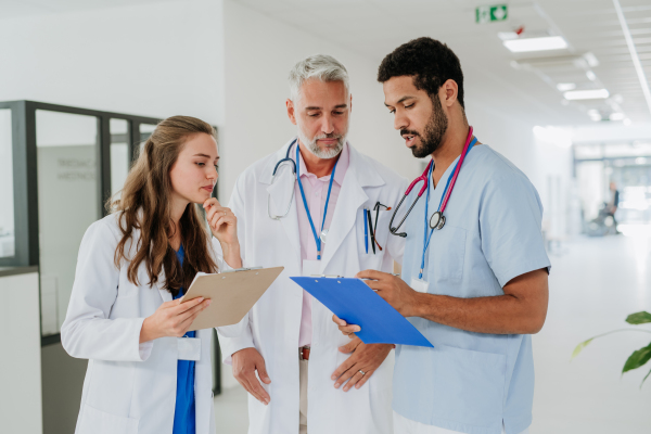 Team of doctors discussing something at a hospital corridor.