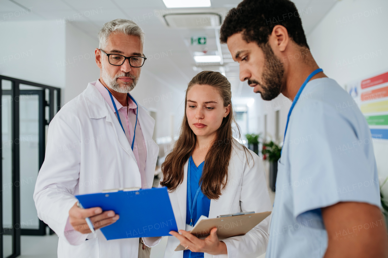 Team of doctors discussing something at a hospital corridor.