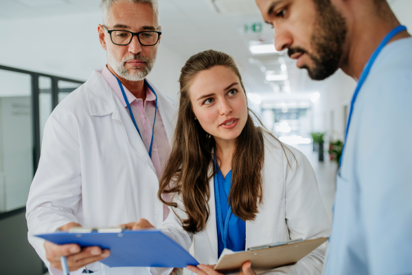 Team of doctors discussing something at a hospital corridor.