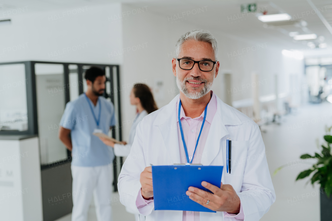 Portrait of mature doctor at a hospital corridor.