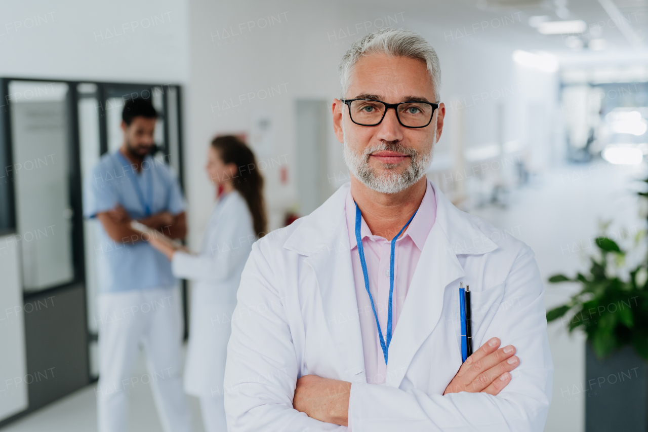 Portrait of mature doctor at a hospital corridor.