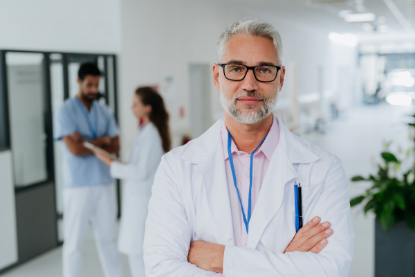 Portrait of mature doctor at a hospital corridor.