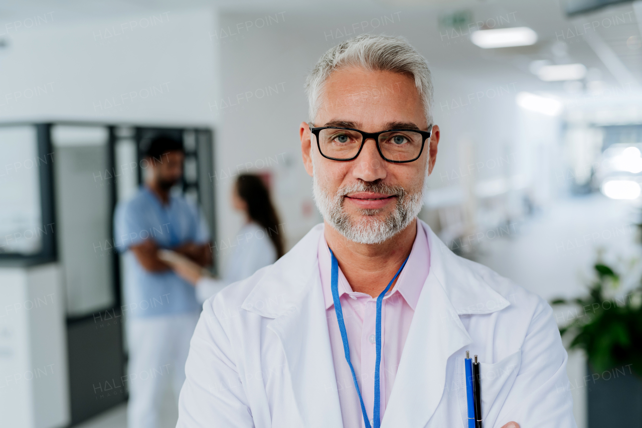 Portrait of mature doctor at a hospital corridor.