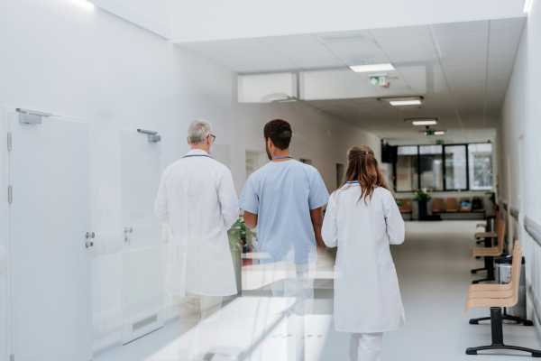 Rear view of medical staff at a hospital corridor.