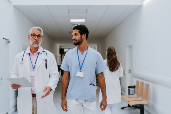 Doctors,colleagues discussing something at a hospital corridor.