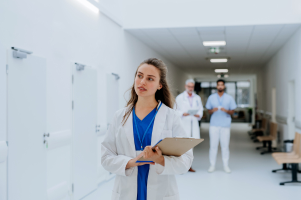 Portrait of young woman doctor at a hospital corridor.