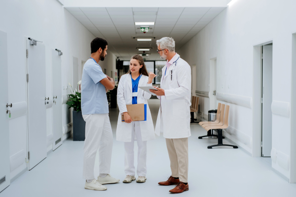 Team of doctors discussing something at a hospital corridor.